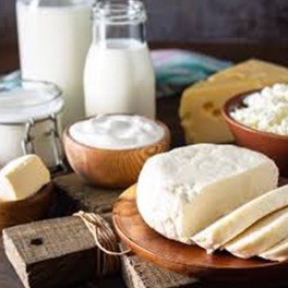 Calcium BHB inspired dairy ingredients including cheese, milk, butter, and cottage cheese arranged on rustic table.